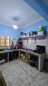 a kitchen with a table and a counter with pots and pans at Sidi hssain in Amizmiz