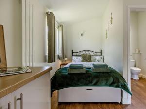 a bedroom with a bed and a bathroom with a sink at 1 Bed in Llangammarch Wells oc-bn020 in Garth