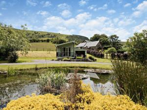a house in the middle of a field with a pond at 1 Bed in Llangammarch Wells oc-bn020 in Garth +21 photos