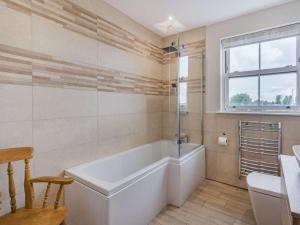 a bathroom with a tub and a toilet and a sink at 3 Bed in Poulton-le-fylde oc-83787 in Hambleton +14 photos