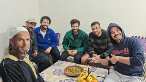 a group of men sitting around a table eating food at Sidi hssain in Amizmiz +13 photos
