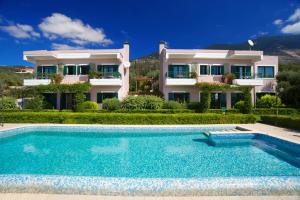 a villa with a swimming pool in front of a house at Felix Residence & Lucia Simona Villas in Mousata