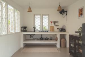 a kitchen with white walls and windows and a sink at Casa Mariposa in Ahangama