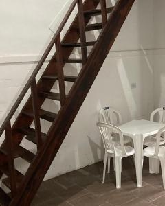 a white table and chairs next to a staircase at Makana Surf Camp in Ubatuba