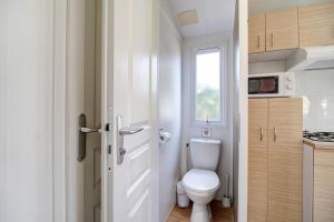 a small bathroom with a toilet and a window at Bungalow Cádiz Costa in Chiclana de la Frontera +18 photos