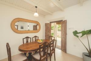 a dining room with a wooden table and chairs and a mirror at Casa Mariposa in Ahangama