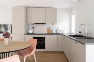 a kitchen with white cabinets and a wooden table at Villa MiaEmilia A in Espoo