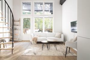 a living room with a white couch and a table at Villa MiaEmilia A in Espoo