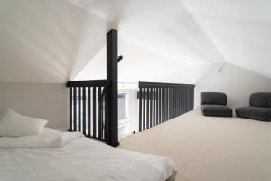a bedroom with a bed and two black chairs at Villa MiaEmilia A in Espoo