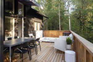 a deck with a table and chairs on a house at Villa MiaEmilia A in Espoo