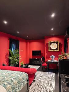 a bedroom with red walls and a bed and a desk at G'Villa Thảo Điền in Ho Chi Minh City