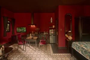 a red room with a kitchen and a table and chairs at G'Villa Thảo Điền in Ho Chi Minh City
