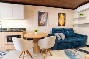 a living room with a blue couch and a table at Studio Completo AC Piscina Pet Friendly NH in Novo Hamburgo