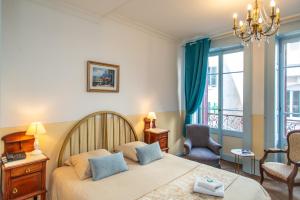 a bedroom with a bed and a window at Hôtel Restaurant Continental in Évian-les-Bains