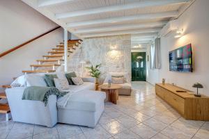 a living room with a white couch and stairs at Ionelia Hospitality Apartments in Ipsos +45 photos