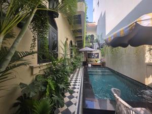 a swimming pool next to a building with plants at G'Villa Thảo Điền in Ho Chi Minh City