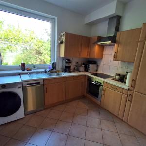 a kitchen with wooden cabinets and a large window at Casa Linda in Rotenburg an der Wümme