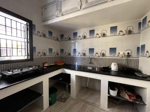 a kitchen with black counters and a sink and a window at De Lemo 3BHK Villa Homestay in Pondicherry