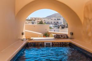 a swimming pool in a house with an arch over it at Casita Suites in Megalochori