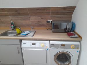 a kitchen with a washing machine and a microwave at Altes Gesellenhaus in Dinklage
