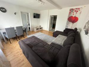a living room with a brown couch and a table at Ferienhaus Weitblick in Masserberg