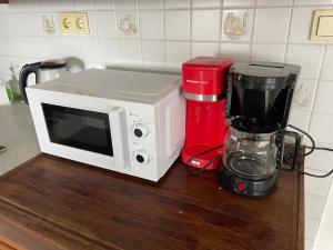 a white microwave sitting on a counter next to a blender at Ferienhaus Weitblick in Masserberg