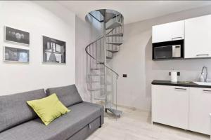 sala de estar con sofá gris y escalera de caracol en Appartamento Aurora en Turín