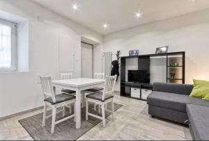 Una sala de estar con una mesa y sillas y un sofá. en Appartamento Aurora, en Turín