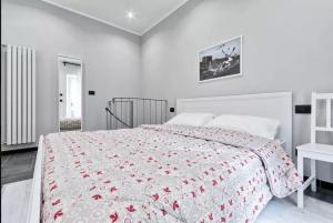 1 dormitorio con 1 cama con colcha roja y blanca en Appartamento Aurora en Turín