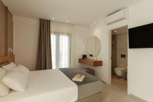 a hotel room with a bed and a mirror at Nami Hotel & Suites in Stalís