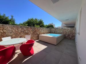 a patio with a table and chairs and a bath tub at Venti D'Amare Suites in Polignano a Mare
