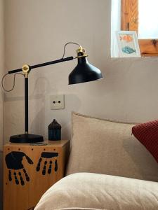 a black lamp sitting on a night stand next to a bed at Peaceful Townhouse Retreat in Órgiva