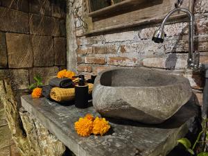 a stone bath tub sitting on a stone wall at Santhiku Hotel & SPA in Lovina