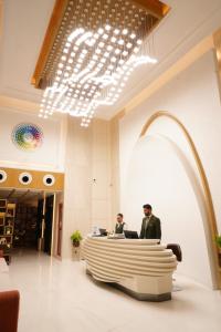 two men sitting at a desk in a lobby at Clarion Inn Greywall By Choice Hotels in Amritsar