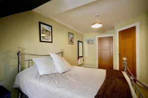a bedroom with a white bed with a wooden door at Wonderful Worthing Beach Walk Flat in Worthing