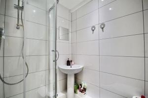 a white bathroom with a sink and a shower at Wonderful Worthing Beach Walk Flat in Worthing +15 photos