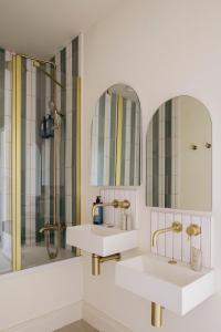 two sinks in a bathroom with two mirrors at Merchant's House in Derry Londonderry