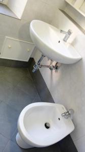 レヴァントにあるFerrando Apartmentの白いトイレ、洗面台付きのバスルーム