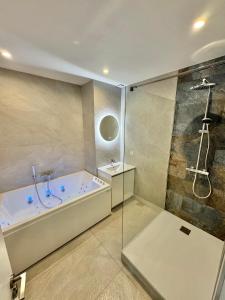 a large bathroom with a tub and a shower at L'escale Mourillon - Plage, Balnéo & Soleil in Toulon