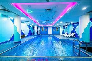 a swimming pool in a hotel with purple lighting at واحد لواحد للشقق المخدومة -اقتصادي in Al Khobar