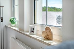 a window sill with a heart picture and a picture frame at Ferienapartment Sunshine in Zwinge +30 photos