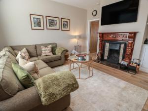 a living room with a couch and a fireplace at Castaway Cottage Maidens in Girvan