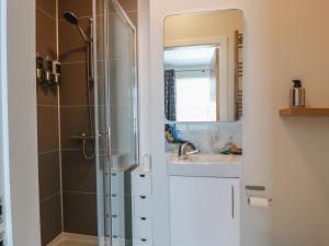 a bathroom with a shower and a sink and a mirror at Castaway Cottage Maidens in Girvan +46 photos