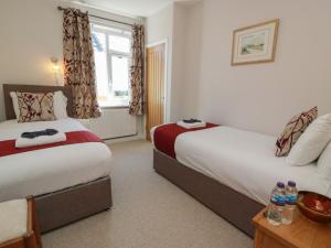 a hotel room with two beds and a window at Castaway Cottage Maidens in Girvan