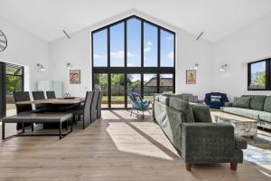 a living room with a table and chairs and a couch at Luxury Norfolk Barn for 12 with Hot Tub , Games Room & EV Car Port in Lenwade