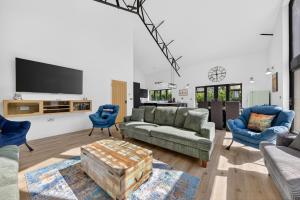 a living room with a couch and a table at Luxury Norfolk Barn for 12 with Hot Tub , Games Room & EV Car Port in Lenwade