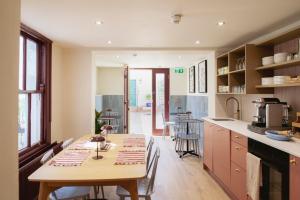 a kitchen with a wooden table and a dining room at Merchant's House in Derry Londonderry +59 photos