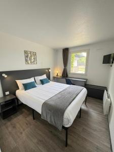a bedroom with a large bed and a window at Logis Hôtel Les Colonnes Strasbourg Zenith in Strasbourg +18 photos