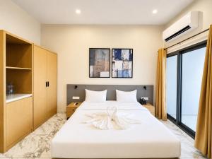 a bedroom with a large white bed and a window at Ixoras Hotel Lemba in Kinshasa