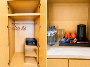 a kitchen with a cupboard with a microwave and water bottles at Ixoras Hotel Lemba in Kinshasa